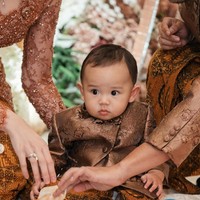 Baby Arash tampil menggemaskan kenakan beskap mini yang dibuat seragam dengan sang ayah. Beskap tersebut dipadukan dengan kain batik senada. Foto: Instagram/@aaliyah.massaid