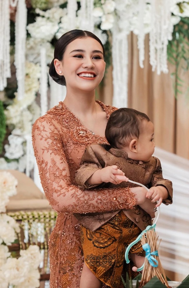 Aaliyah cantik memukau kenakan kebaya panjang bernuansa coklat dengan detail bordir dan payet. Modelnya fitted mengikuti lekuk tubuh, memberi kesan anggun dan elegan. Foto: Instagram/@aaliyah.massaid