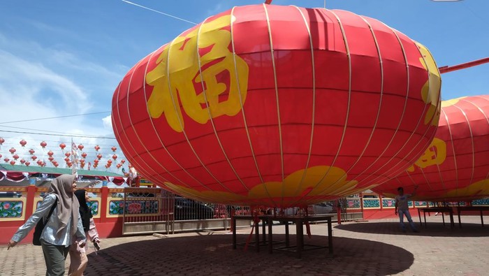 Seorang pengunjung melihat satu dari dua lampion raksasa di Wihara Tri Dharma Hian Tian Siang Tie, Sungai Kakap, Kabupaten Kubu Raya, Kalimantan Barat, Sabtu (14/2/2026). Sebanyak dua lampion raksasa dengan ukuran lingkaran keliling 22,8 meter, berdiameter 7,26 meter, dan tinggi 4,4 meter tersebut dipersiapkan untuk menyemarakkan perayaan Tahun Baru Imlek 2577 Kongzili dan Cap Go Meh, sekaligus untuk menarik wisatawan berkunjung ke kelenteng yang berusia lebih dari 100 tahun itu. ANTARA FOTO/Jessica Wuysang/rwa.