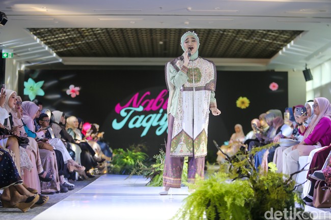 Nabila tampil mengenakan busana three-piece yang terdiri dari kemeja hijau sage sebagai lapisan dalam, dipadukan dengan outer panjang tanpa lengan bermotif etnik yang dominan warna putih dan hijau dari brand Heart Troops. Foto: Andhika Prasetia/detikFoto.