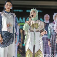 Keseluruhan look ini disempurnakan dengan celana panjang longgar berwarna cokelat tua yang memiliki detail motif etnik di bagian bawah, menciptakan keselarasan gaya yang elegan. Foto: Andhika Prasetia/detikFoto.