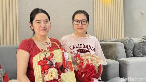 Pemilik Dapoer Nai Nai Yuni Then (kiri) dan adiknya menujukkan hampers edisi khusus Tahun Baru Imlek, Sabtu (14/2/2026). (Foto: Maria Christabel DK/detikBali)