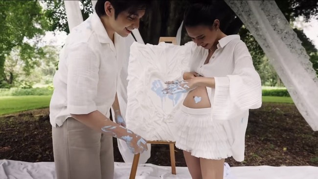 Shenina mengenakan kemeja lengan panjang dengan kancing perut terbuka, memperlihatkan baby bump yang mulai membesar. Kemeja tersebut dipadukan dengan rok pendek yang juga berwarna putih. Foto: Instagram/@sheninacinnamon