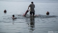 Terlihat orang tua mendampingi anaknya saat bermain di pantai Ancol, Jakarta.