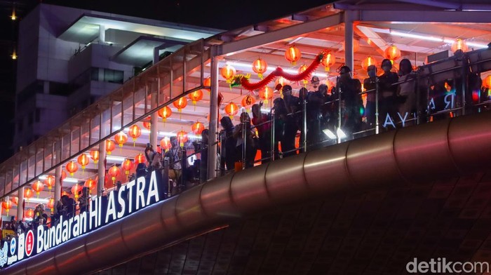 Ribuan warga memadati kawasan Bundaran HI Jakarta untuk menyaksikan perayaan Tahun Baru Imlek yang meriah. Lampion merah menghiasi area sekitar, menciptakan suasana bercahaya yang menarik pengunjung untuk berkumpul dan mengabadikan momen bersama keluarga maupun teman.