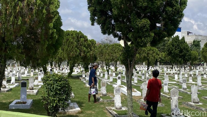 Tukang cat makam di Taman Makam Pahlawan Medan