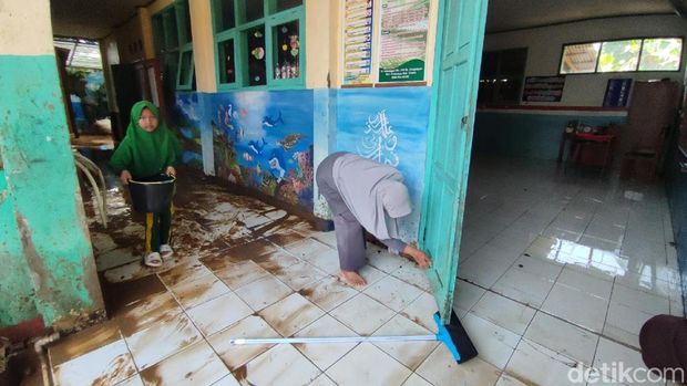 Aksi warga bersih-bersih usai banjir surut sehari menjelang Bulan Ramadan di Pamarican Ciamis.