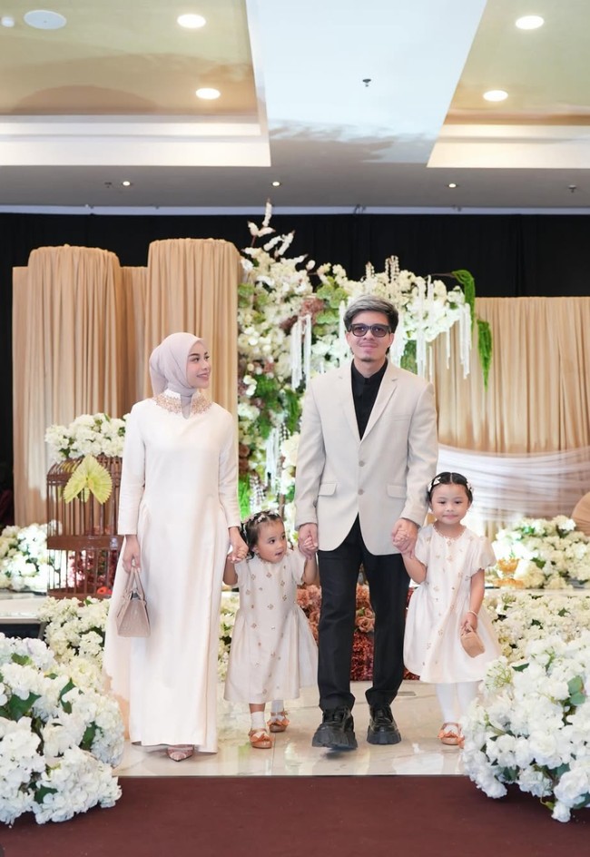 Aurel memilih dress panjang berwarna cream dengan potongan lurus dan longgar. Siluetnya sederhana namun tetap memperlihatkan bentuk tubuh yang kini terlihat makin langsing. Detail high neckline dengan aksen payet atau bordir di bagian kerah menambah sentuhan mewah. Foto: Instagram/@aurelie.hermansyah