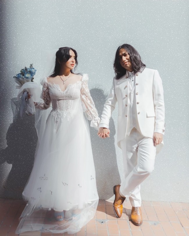 Ayushita tampil dreamy dalam balutan gaun vintage romantis dan sedikit sentuhan bohemian, sementara Gerald mengenakan setelan off-white berupa blazer dengan aksen kancing metal yang memberi kesan militer. Foto: Instagram @geraldsitumorang/ @ayushita