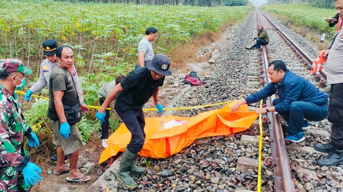 Petugas mengevakuasi mayat pria tertabrak kereta di Simalungun. (Dok Polres Simalungun)