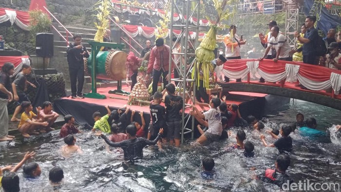 Rebutan udik-udik kue apem di pembukaan Padusan OMAC Klaten, Selasa (17/2/2026).