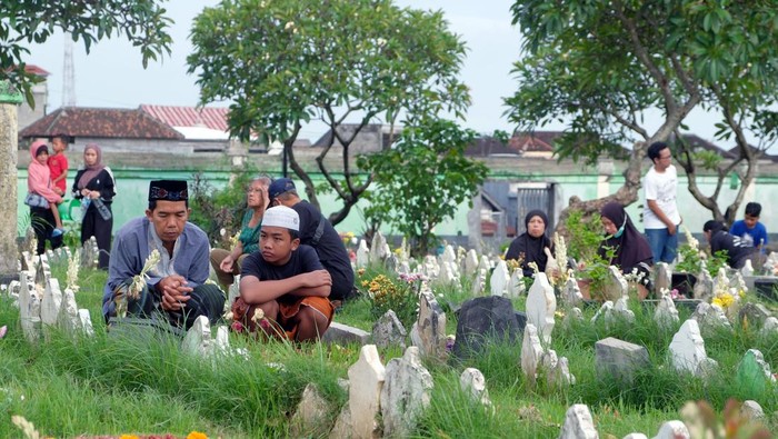 Umat Islam berdoa di sisi makam keluarganya saat tradisi ziarah kubur menjelang bulan suci Ramadhan di Pemakaman Muslim Wanasari, Denpasar, Bali, Senin (16/2/2026). Menurut pengurus Yayasan Muslim Wanasari Maruti Tiga Belas, sejak Jumat (13/2) sudah 