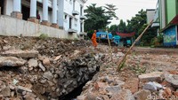 Petugas Sumber Daya Air Jakarta Selatan melakukan pengerukan saluran air yang tersumbat material longsoran guna mencegah genangan saat hujan.  