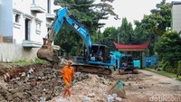 Petugas mengamankan area proyek untuk memastikan keselamatan siswa dan warga sekitar selama proses perbaikan berlangsung.  