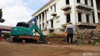 Alat berat dikerahkan untuk mengangkut sisa material tembok yang roboh akibat struktur tanah yang labil.  