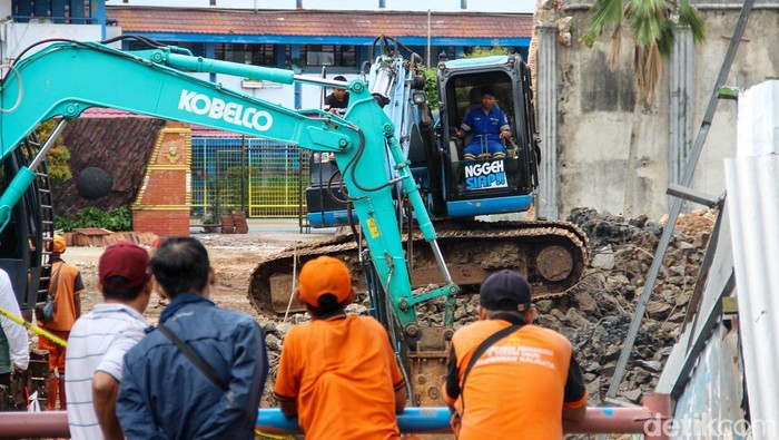 Sejumlah warga menyaksikan perbaikan prasarana SMPN 182 yang terus dikebut. Pekerjaan berlangsung Rabu (18/2/2026) di Kalibata, Jakarta Selatan.