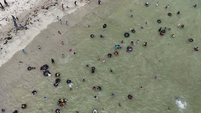 Foto udara Sejumlah pengunjung memandikan anak-anaknya pada tradisi mandi laut jelang Ramadhan di Desa Lhok Bubon, Kecamatan Samatiga, Aceh Barat, Aceh, Rabu (18/2/2026). Tradisi mandi laut yang dilakukan sebagian masyarakat Aceh secara turun-temurun tersebut bertujuan untuk membersihkan diri dalam rangka menyambut bulan suci Ramadhan 1447 Hijriah. ANTARA FOTO/Syifa Yulinnas