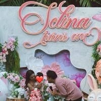 Digelar outdoor, dekorasi acara tampak bernuansa pink dengan dihiasi beragam bunga bernuansa senada serta tulisan Selina Turns One. Kue ulang tahun Selina juga didesain dengan warna pink yang tersusun dari 2 tingkat. Foto: Instagram/@mykylinz_