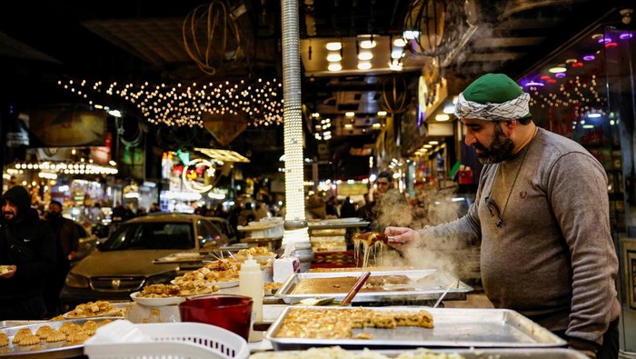 A vendor prepares trays of hot food at a street stall as Muslims prepare for the holy month of Ramadan in Damascus, Syria, February 18, 2026. REUTERS/Yamam Al Shaar