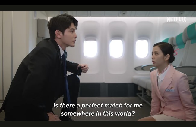 Tak ketinggalan, ada mantan personel Wanna One, Ong Seung Woo memakai setelan jas dan melindungi Jisoo BLACKPINK dari serangan tak terduga dalam pesawat. Penggemar dapat mengikuti perjalanan cinta Jisoo di Boyfriend on Demand, yang tayang di Netflix pada 6 Maret 2026. Foto: dok. Netflix