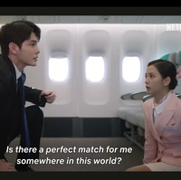 Tak ketinggalan, ada mantan personel Wanna One, Ong Seung Woo memakai setelan jas dan melindungi Jisoo BLACKPINK dari serangan tak terduga dalam pesawat. Penggemar dapat mengikuti perjalanan cinta Jisoo di Boyfriend on Demand, yang tayang di Netflix pada 6 Maret 2026. Foto: dok. Netflix