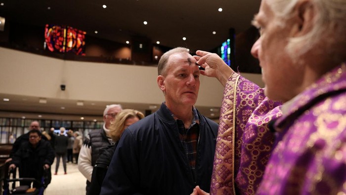 A person receives the imposition of ashes during Ash Wednesday Mass at St. Olaf Catholic Church in Minneapolis, Minnesota, U.S. February 18, 2026.  REUTERS/Go Nakamura