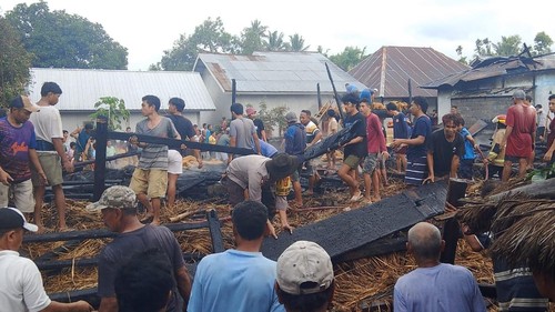 Warga bersama petugas Damkarmat dan kepolisian bergotong royong membersihkan sisa puing Bale Beleq Timuk Orong yang ludes terbakar, Kamis (19/2/2026). (Foto: Dok. Polsek Bayan)