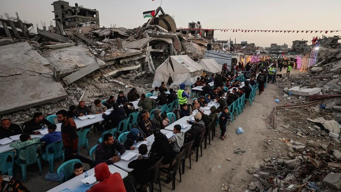 Palestinians gather to break their fast by eating Iftar meals on the first day of the holy month of Ramadan, near the rubble of residential buildings destroyed during the two-year Israeli offensive, in Gaza City, February 18, 2026. REUTERS/Dawoud Abu Alkas     TPX IMAGES OF THE DAY