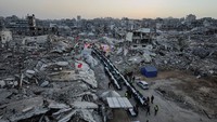 Mereka menyantap hidangan iftar di dekat reruntuhan bangunan permukiman yang hancur akibat ofensif Israel selama dua tahun terakhir. REUTERS/Dawoud Abu Alkas  