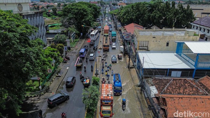 Kendaraan terjebak macet di Jalan Raya Teuku Umar, Jumat (20/2/2026), akibat genangan air yang menutup sebagian badan jalan.