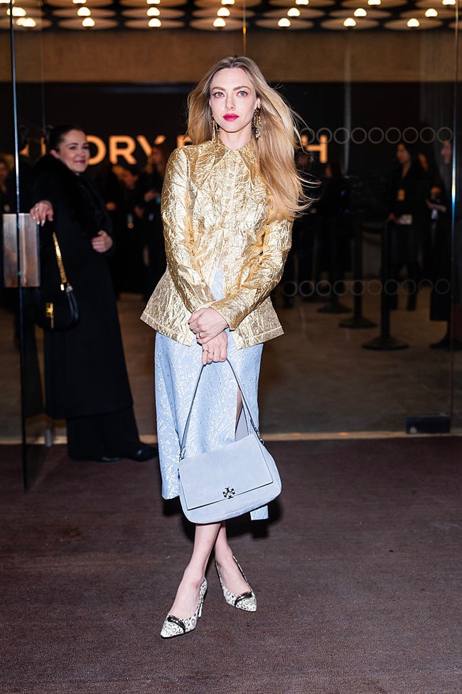 Amanda Seyfried membawa aura gilded age dengan jaket emas yang dipadu midi skirt biru nan polish. Klasik tapi terasa effortless dan chic. (Foto: TheStewartofNY/GC Images)