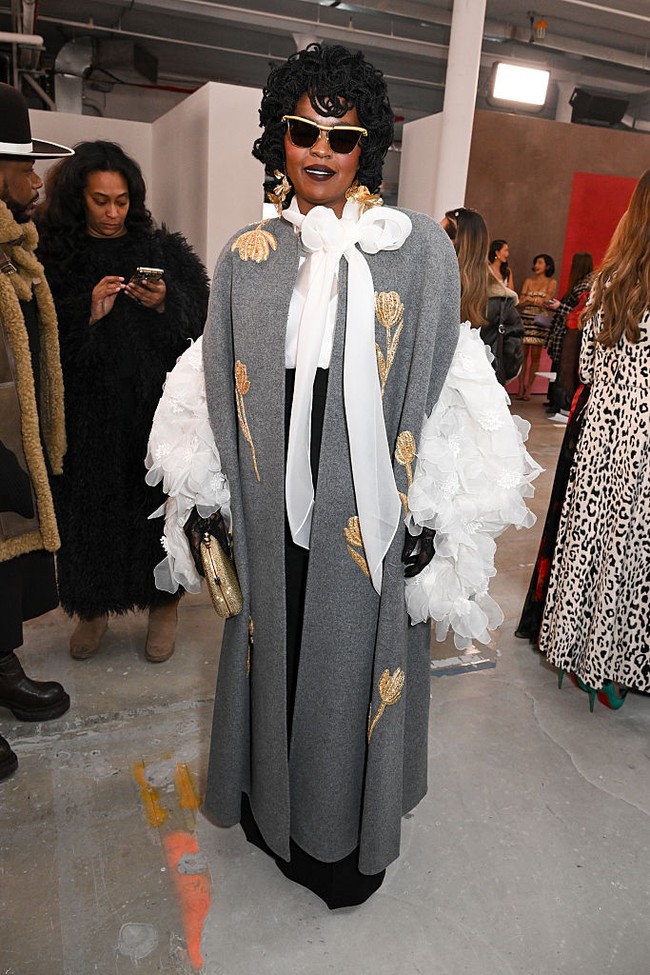 Jarang muncul di hadapan publik, ratu soul 90-an Lauryn Hill menampakkan dirinya di peragaan Carolina Herrera dengan coat bordir emas nan elegan. Elemen dramatis hadir lewat pita besar dan permainan ruffle volume pada blusnya.  Foto: Gilbert Flores/WWD via Getty Images