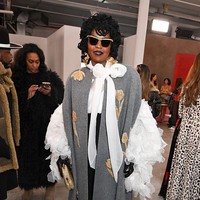 Jarang muncul di hadapan publik, ratu soul 90-an Lauryn Hill menampakkan dirinya di peragaan Carolina Herrera dengan coat bordir emas nan elegan. Elemen dramatis hadir lewat pita besar dan permainan ruffle volume pada blusnya.  Foto: Gilbert Flores/WWD via Getty Images