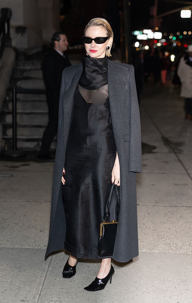 Namoi Watts tampil elegan dan seksi di fashion show Khaite. Ia memakai high-collared little black dress dengan see-through twist pada area dada.  (Foto: Gilbert Carrasquillo/GC Images)