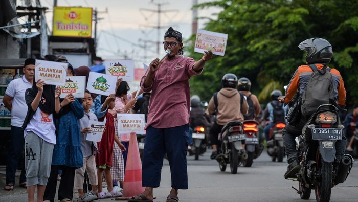 Warga mengambil hidangan makanan untuk buka puasa bersama di Kampoeng Ramadhan, Perumahan Graha Mutiara Permai 2, Kabupaten Tangerang, Banten, Kamis (19/2/2025). Kegiatan yang diselenggarakan oleh warga perumahan tersebut menyiapkan sebanyak 700 porsi hidangan buka puasa gratis selama 22 hari bulan suci Ramadhan 1447 Hijriah untuk pengendara yang dalam perjalanan dan warga kurang mampu. ANTARA FOTO/Putra M. Akbar/foc.