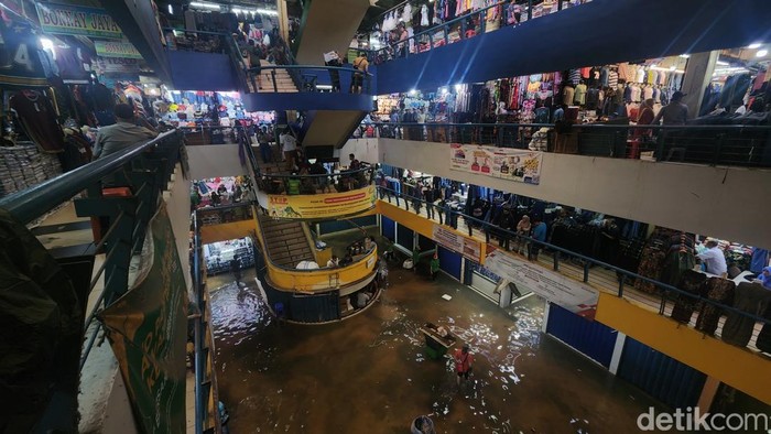 Aktivitas jual beli tetap berlangsung di Pasar Cipulir, Jumat (20/2/2026), meski genangan air mencapai sekitar 50 sentimeter akibat luapan Kali Pesanggrahan.