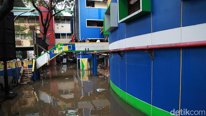 Aktivitas jual beli tetap berlangsung di Pasar Cipulir, Jumat (20/2/2026), meski genangan air mencapai sekitar 50 sentimeter akibat luapan Kali Pesanggrahan.