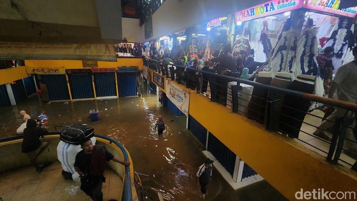 Aktivitas jual beli tetap berlangsung di Pasar Cipulir, Jumat (20/2/2026), meski genangan air mencapai sekitar 50 sentimeter akibat luapan Kali Pesanggrahan.
