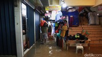 Sejumlah pedagang mengangkat barang dagangan agar tidak terendam saat banjir menggenangi Pasar Cipulir hingga setinggi lutut orang dewasa.