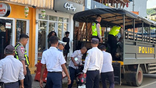 Personel Satlantas Polres Manggarai Barat mengangkut sepeda motor parkir liar di Jalan Soekarno-Hatta Labuan Bajo, Manggarai Barat, NTT, Jumat (20/2/2026).