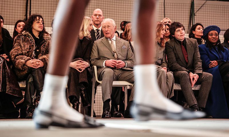 LONDON, ENGLAND - FEBRUARY 19: King Charles III sits next to CEO of the British Fashion Council Laura Weir on the front row for British-Nigerian designer Tolu Coker, the opening show of London fashion week on February 19, 2026 in London, England. (Photo by Richard Pohle - WPA Pool/Getty Images)
