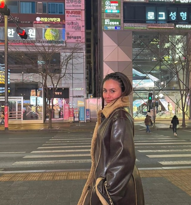 Wulan tampil standout dengan coat panjang berbahan kulit berwarna cokelat tua. Bagian dalam coat dilapisi bulu shearling warna krem yang memberi kesan hangat sekaligus mewah. Potongan panjangnya membuat tampilan terlihat elegan dan cocok untuk cuaca dingin Korea. Foto: Instagram/@wulanguritno