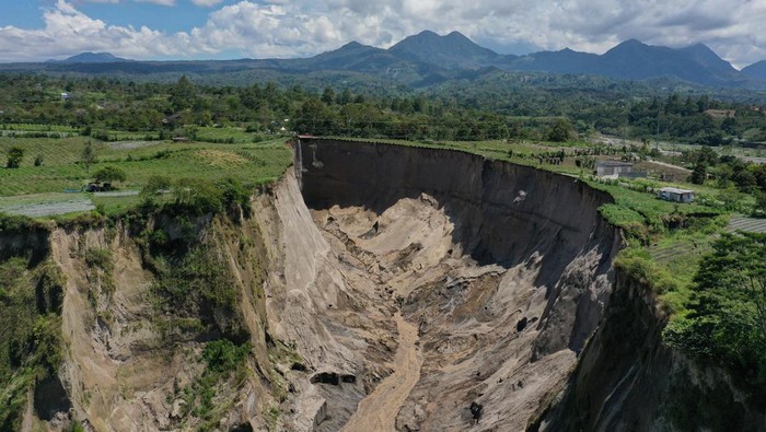 Foto udara kondisi longsoran tanah raksasa di Desa Pondok Balik, Kabupaten Aceh Tengah, Aceh, Jumat (20/2/2026). Longsoran tanah raksasa yang membentuk lubang raksasa seluas lebih dari 30 ribu meter persegi tersebut memutus akses antarkecamatan di Aceh Tengah serta menenggelamkan lahan perkebunan warga setempat. ANTARA FOTO/Arnas Padda/YU