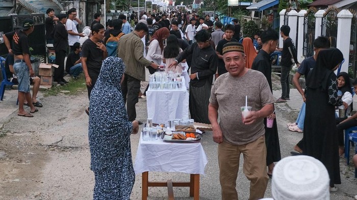 Ratusan warga mengambil takjil pada meja hidangan saat acara buka puasa bersama di Lorong Bahagia, Kelurahan Bonggoeya, Kendari, Sulawesi Tenggara, Minggu (22/2/2026). Acara buka puasa bersama yang dilakukan pada jalan sepanjang 150 meter dengan total 100 meja hidangan tersebut diinisiasi oleh Kerukunan Keluarga Pemuda Bahagia sebagai bentuk kebersamaan dan suka cita dalam menyemarakkan bulan suci Ramadhan. ANTARA FOTO/Andry Denisah