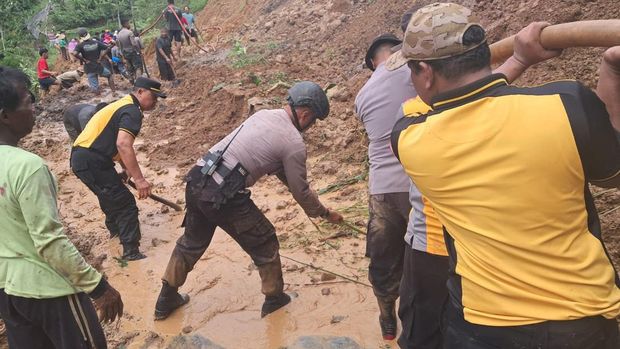 Personel Polres Karanganyar saat membersihkan material longsor di jalan di Desa Kedawung, Kecamatan Jumapolo, Kabupaten Karanganyar.
