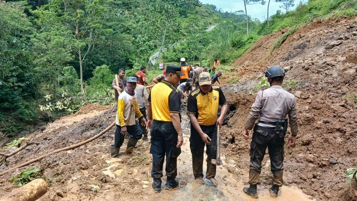 Personel Polres Karanganyar saat membersihkan material longsor di jalan di Desa Kedawung, Kecamatan Jumapolo, Kabupaten Karanganyar.