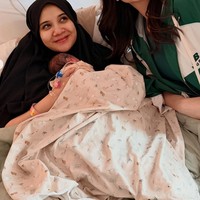 Penampilan Zaskia terlihat natural dan tetap tertutup dengan hijab hitam di kepalanya. Ia tersenyum sambil menggendong bayi mungilnya. Foto: Instagram/@raffinagita1717