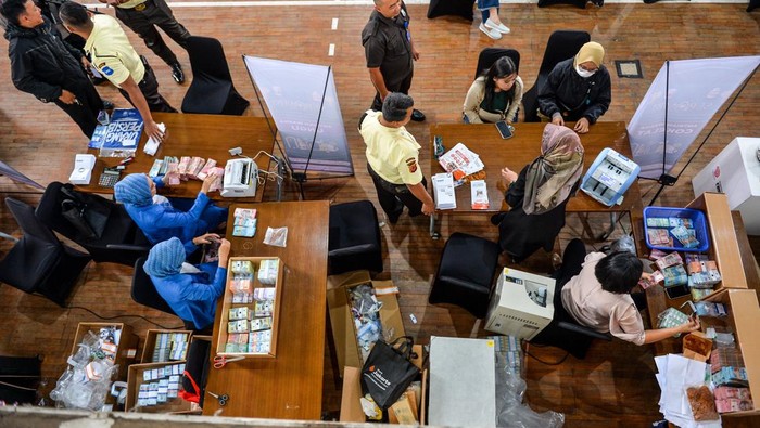 Petugas melayani warga untuk menukar pecahan uang saat pelayanan penukaran uang di Gor Saparua, Bandung, Jawa Barat, Senin (23/2/2026). Bank Indonesia (BI) menyiapkan Rp8,6 triliun untuk layanan penukaran uang dengan nominal sebesar Rp5,3 juta per paket serta layanan penukaran tersedia di 2.883 titik di Indonesia dengan total 8.755 layanan oleh BI dan perbankan lainnya pada 2026 . ANTARA FOTO/Raisan Al Farisi/YU