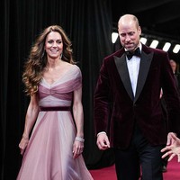 Pangeran William tampil serasi dalam balutan Emporio Armani Velvet Evening Jacket berwarna merah gelap, senada dengan ikat pinggang yang dikenakan Kate. Foto: BAFTA via Getty Images/Scott Garfitt