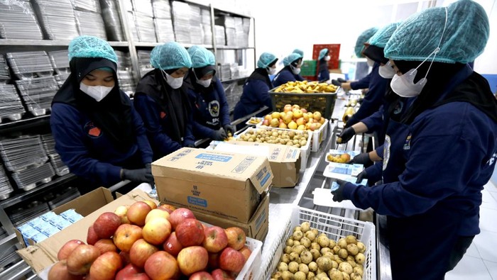Karyawan mengemas paket makanan bergizi gratis (MBG) di Satuan Pelayanan Pemenuhan Gizi (SPPG) Pentadio Barat, Kabupaten Gorontalo, Gorontalo, Senin (23/2/2026). Penerima MBG mendapatkan dua kali paket dalam satu pekan berupa susu, buah, kacang, roti